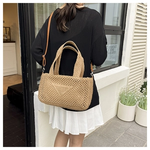 Detail der handgewebten Strohtasche mit hohlem Strickmuster und Lederband