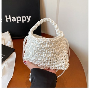 Detail of white handmade woven mini handbag showing chunky knit texture and round handle