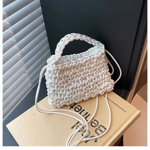 Close-up of white chunky rope weave handbag on a vintage book with soft shadow