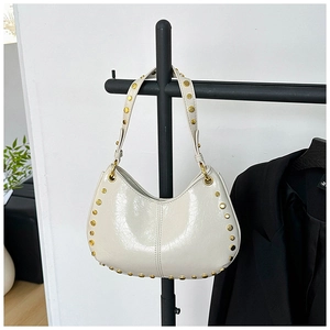 Detailed view of white Hobo bag with vintage gold rivets on shoulder strap and seams
