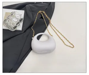 Mini sac demi-lune en acrylique blanc avec un smartphone pour comparer la taille réelle