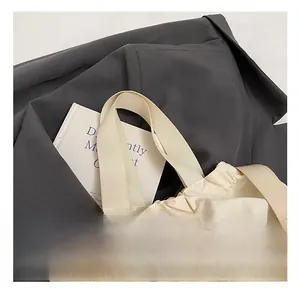 Detail of cream white canvas tote bag with nylon handles and adjustable drawstring closure