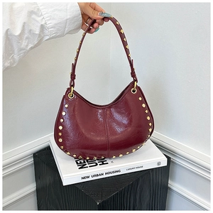 Detail view of burgundy leather hobo bag with vintage gold studs and smooth texture