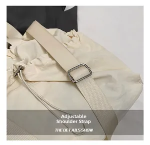 Detail of adjustable shoulder strap and drawstring closure on a nylon crossbody bag