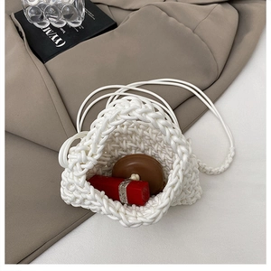 Detail of hand-woven white mini bag showing interior storage for lipstick and accessories