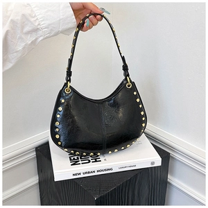 Detailed view of black retro rivet hobo bag with glossy patent leather texture