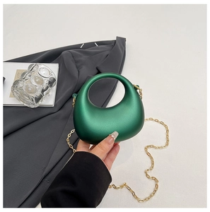 Mini metallic green half-moon handbag with integrated handle and gold chain strap