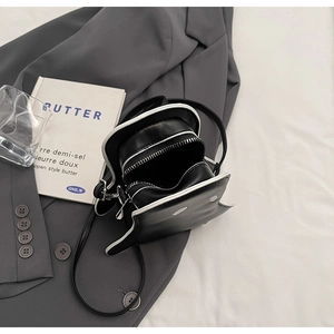 Detail view of mini black ghost crossbody bag showing zipper and interior capacity