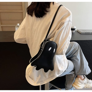 Detailed view of the ghost-shaped black PU leather crossbody bag worn by a model