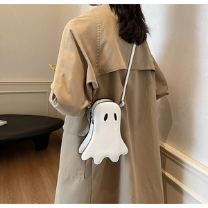 Stylishly cute white ghost shoulder bag worn by model over a khaki trench coat