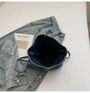 Vue de dessus d'un sac seau en denim bleu montrant un intérieur spacieux et des anses