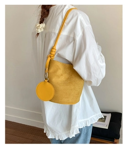 Detail of yellow matte bucket bag with matching round coin purse and slim shoulder strap