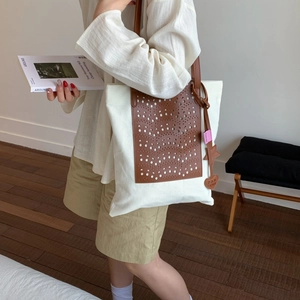 Retro canvas tote bag with brown laser-cut leather hollow design and shoulder strap