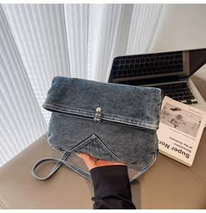 Détail macro du sac besace rétro en jean avec texture délavée et bouton-pression métal