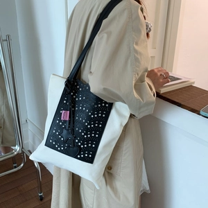 Retro canvas shoulder bag in cream and black with laser-cut pocket and charms