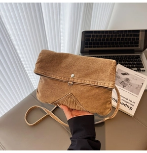 Vue détaillée d'une besace vintage en jean marron avec boucle métallique argentée