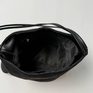 Minimalist matte black bucket bag with a spacious interior and metal zipper pocket