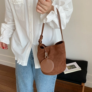 Close-up of brown matte suede bucket bag featuring a decorative knot and coin purse