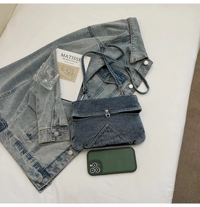 Détail du sac bandoulière en denim bleu foncé montrant l'espace pour un smartphone