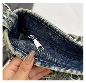 Détail macro de la fermeture éclair en métal et de la texture du tissu denim délavé