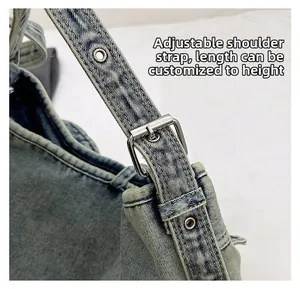 Gros plan sur la bandoulière réglable en denim avec œillets métalliques et boucle