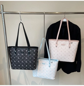Detailed display of three tote bags in black pink and blue with deer patterns