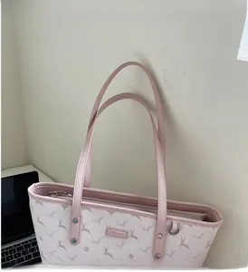 Close-up of pink tote bag with reindeer print showing leather handles and metal rivets