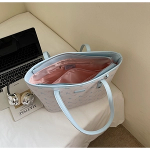 Interior view of light blue tote bag showing pink lining, zip pocket and large capacity