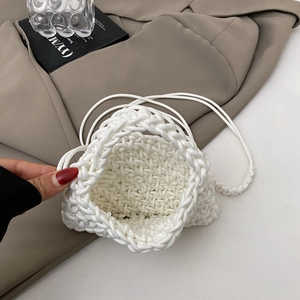 Minimalist white woven bucket bag showing internal space against a stylish background