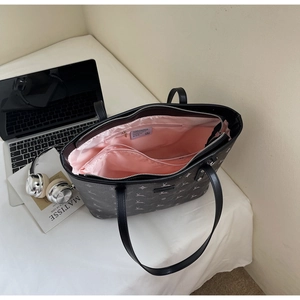 Top view of large tote bag with deer pattern, pink lining, and a laptop inside