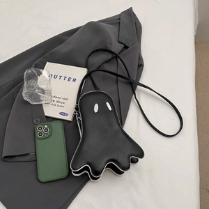 Ghost-shaped black leather shoulder bag with white piping on a grey blazer outfit