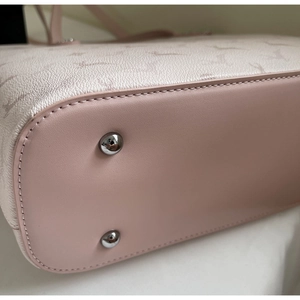 Detail view of pink tote bag base with protective silver studs and refined stitching