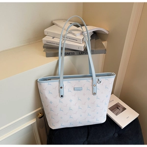 Detail of deer pattern printed tote bag with light blue handles and silver metal rivets