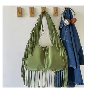 Detail of olive green suede tote bag featuring long fringes and bohemian tassel accents
