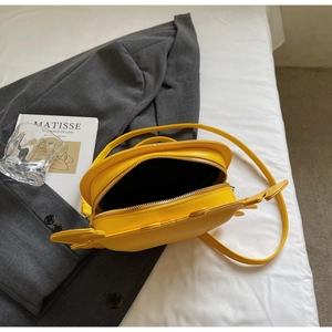 Close-up detail of a creative yellow crab-shaped crossbody bag showing the open zipper