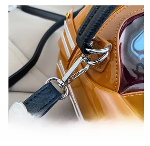 Macro shot of silver metal hooks and black leather straps on a car-shaped lacquer bag