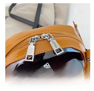 Detailed close-up of smooth silver dual metal zippers on a yellow cartoon car handbag