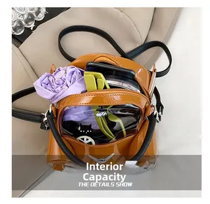 Detail view of the brown patent leather car bag with clear window and internal storage