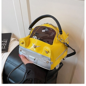 Detail view of yellow vintage car-shaped handbag with glossy finish and cat graphics