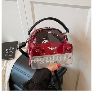 Detail of red car-shaped handbag in glossy patent leather with black cat window design