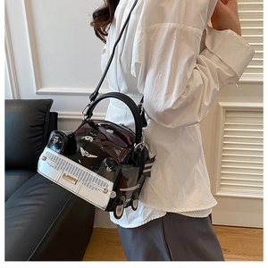 Detail of creative vintage car shaped handbag with black and white patent leather finish