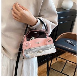 Detail of pink vintage car shaped handbag with glossy leather finish and cat logo