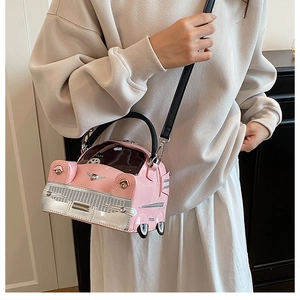Detail of pink classic car shaped handbag with silver metal grille and black strap