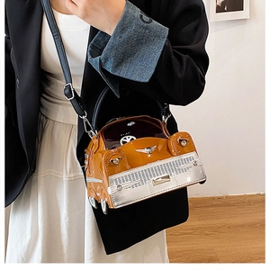 Detail of yellow car-shaped handbag with glossy finish and silver metal accents