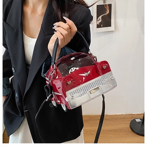 Close-up of a creative red car-shaped crossbody bag with metallic details and PVC windows