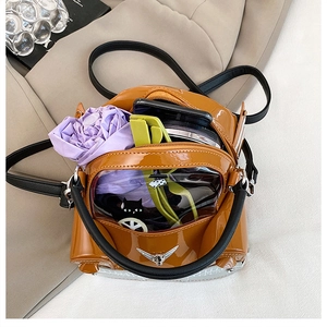 Detail of interior storage in a brown car-shaped crossbody bag with polished patent finish