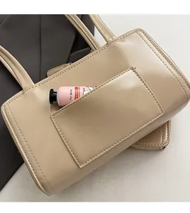 Dettaglio della borsa a spalla beige minimalista con tasca posteriore antifurto funzionale