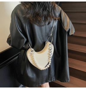 Dettaglio borsa cuore bianco crema con cinturino in perle e catena cuore in argento