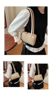 Dettaglio della borsa a spalla baguette beige con un piccolo portamonete coordinato ed elegante