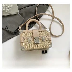 Macro view of woven box bag with tan leather trim and smartphone for size reference